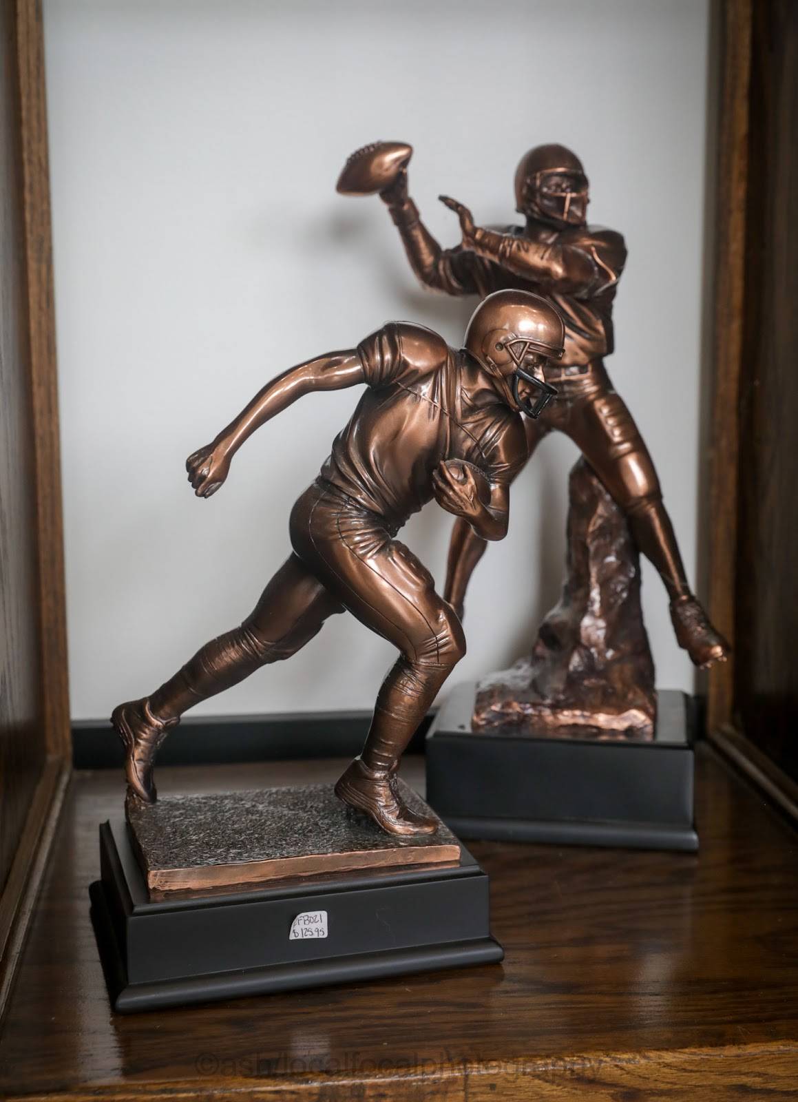 Bronze-finish football player figures on display at Trophy Shop Oxford