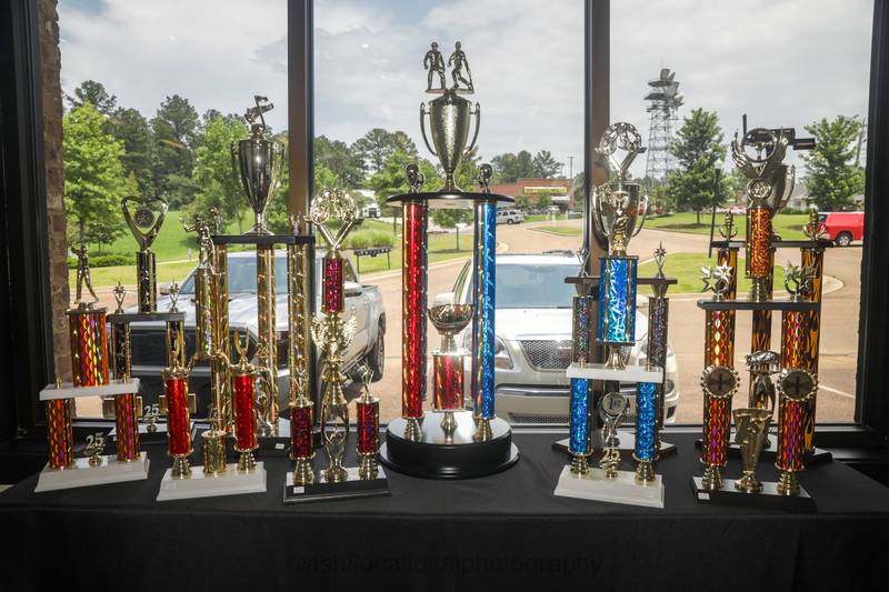 Column trophies lined up on a table in the shop window